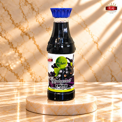RAJ Pulpy Tree Blackcurrant Crush bottle with a blue cap on an ivory and gold marble podium.