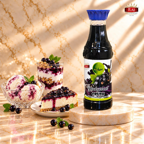RAJ Pulpy Tree Blackcurrant Crush bottle with berry-filled layer cake, fruit tart, macarons and chocolate.