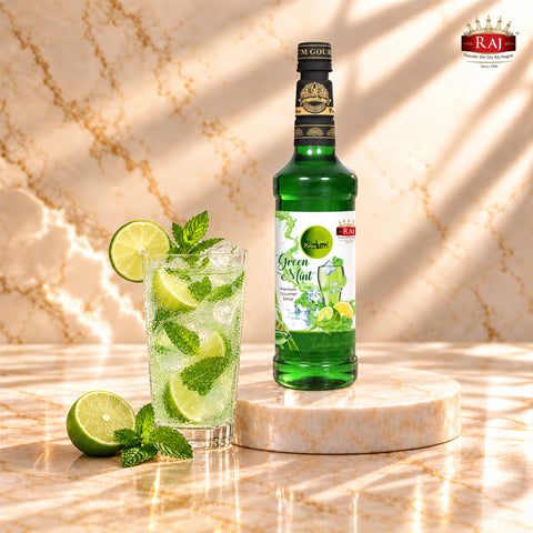 RAJ Pulpy Tree Green Mint syrup bottle beside a mint mocktail with fresh lime, mint leaves and ice.