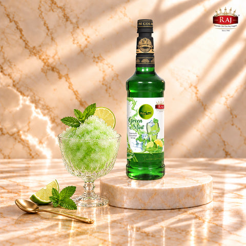 RAJ Pulpy Tree Green Mint syrup bottle beside a frozen green mint slush garnished with mint leaves and lime.