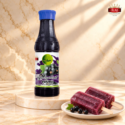 Blackcurrant Crush bottle beside two homemade blackcurrant ice pops on wooden sticks