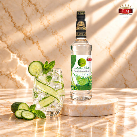 RAJ Pulpy Tree Mojito Mint syrup bottle beside a cucumber mint cooler with cucumber ribbons and ice