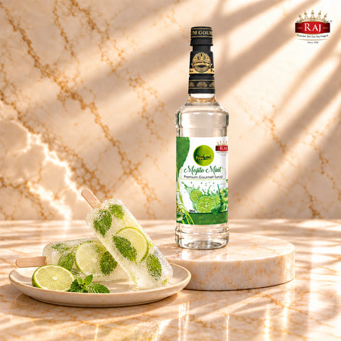 RAJ Pulpy Tree Mojito Mint syrup bottle beside translucent mint lime popsicles on an ivory serving plate.