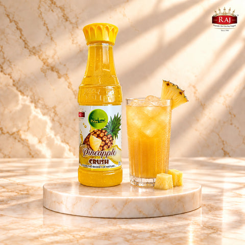 RAJ Pulpy Tree Pineapple Crush bottle beside an iced pineapple cooler with fresh pineapple pieces
