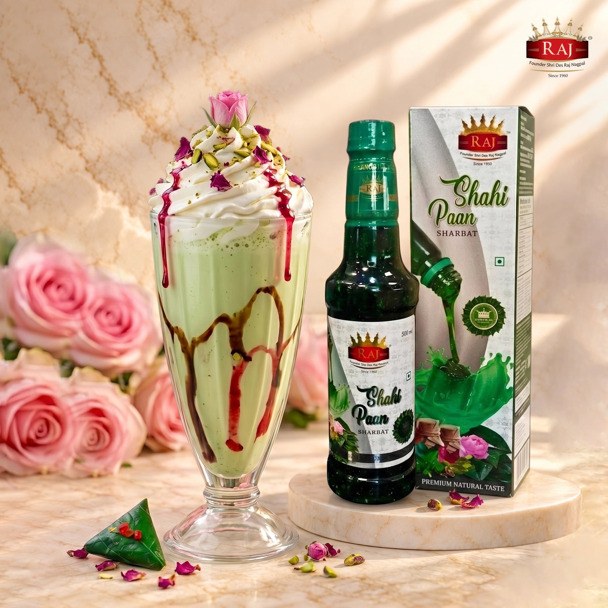 Shahi Paan Milkshake with whipped cream, rose syrup and pistachios next to RAJ Shahi Paan Sharbat 500 ml bottle and carton