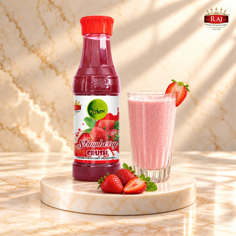RAJ Pulpy Tree Strawberry Crush bottle with strawberry milkshake and fresh strawberries on a marble podium